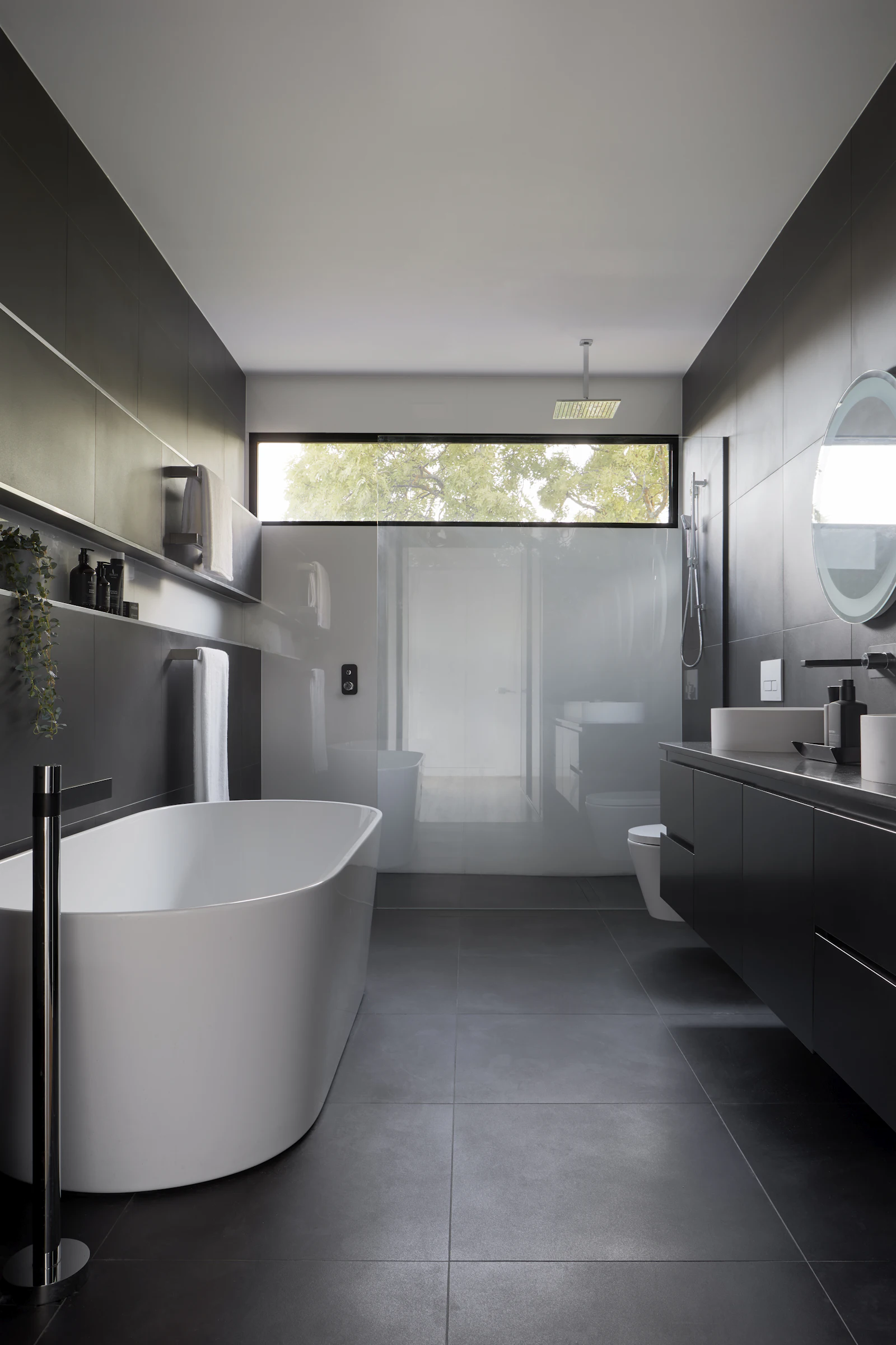 Minimal bathroom with freestanding bath and clerestory window